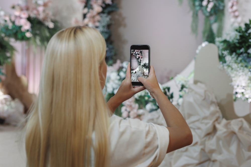 Wedding planner taking photos of floral decor for social media marketing for wedding venues.